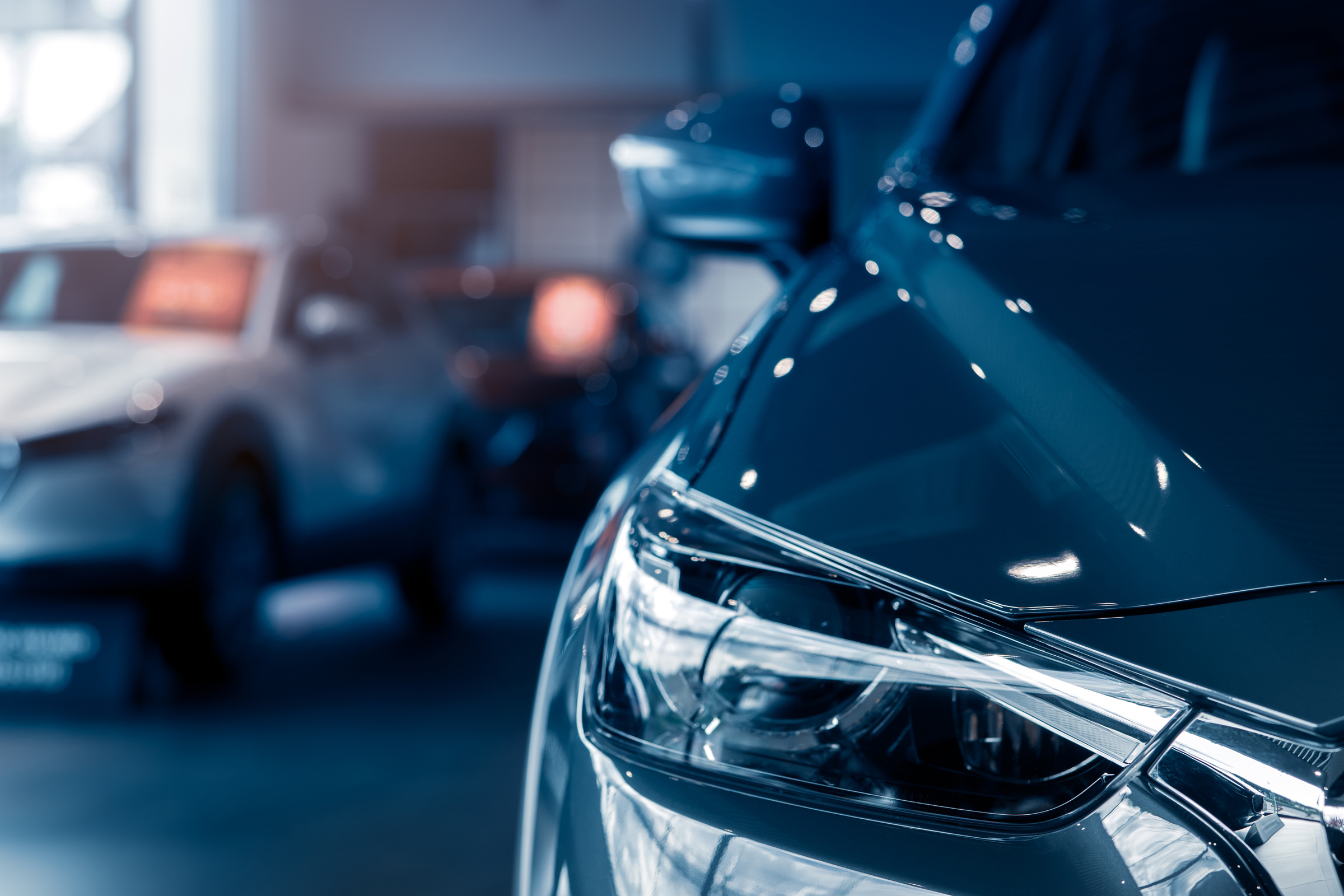 Selective focus grey car parked in luxury showroom. Car deal